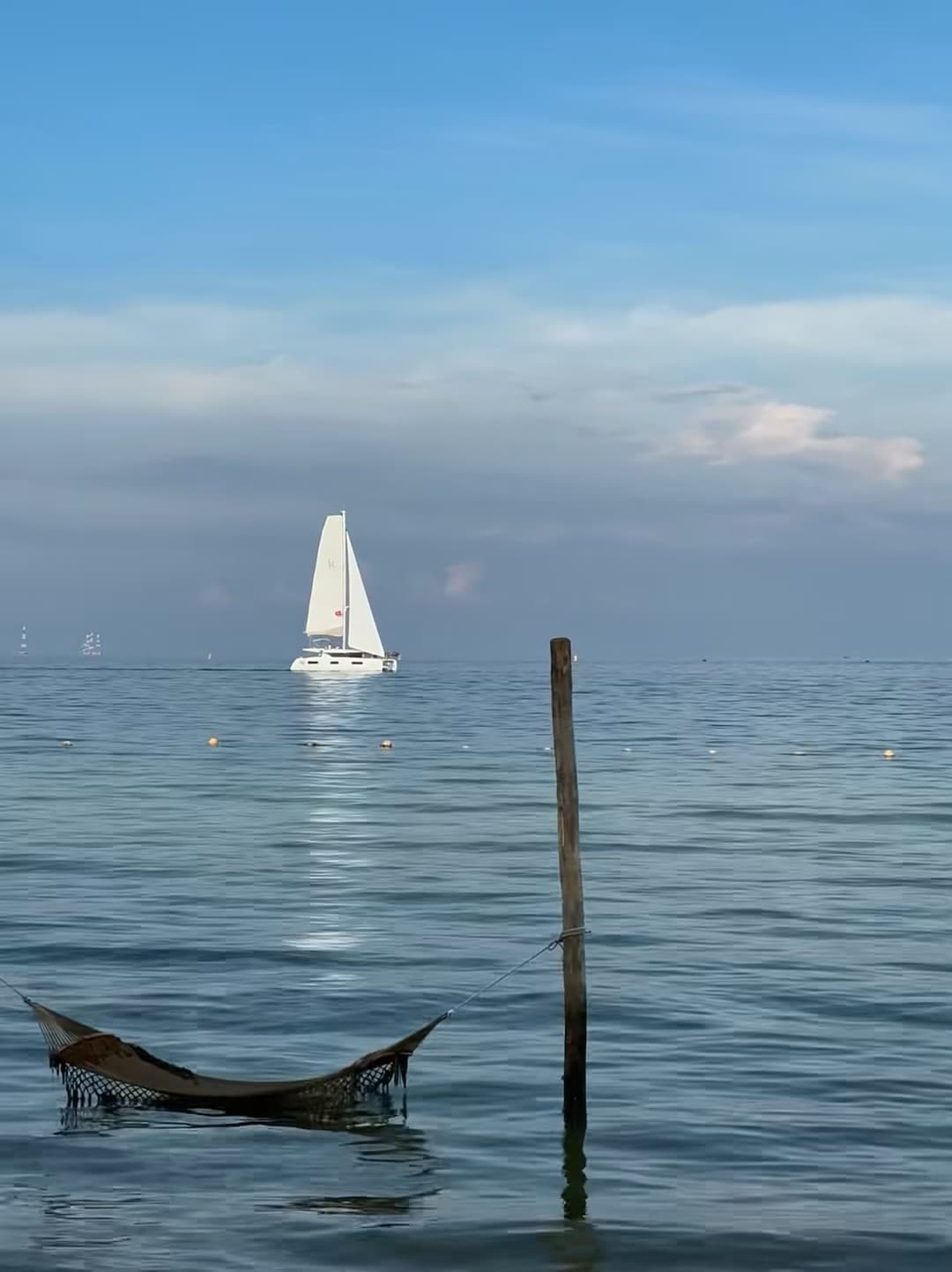 海风把 hammock 吹得像在跳舞 🌊 停泊的帆船是今天的背景板封面图