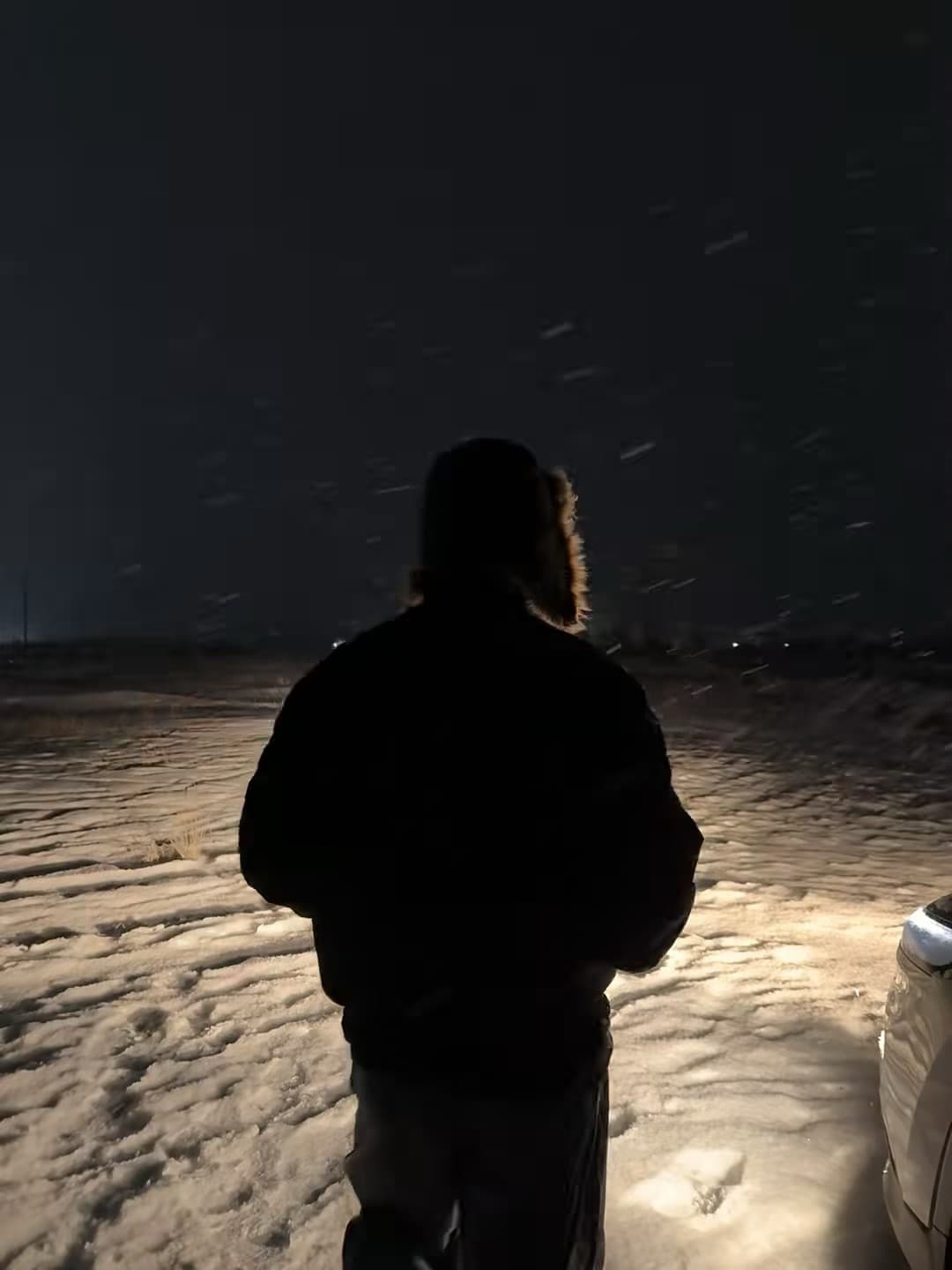 雪夜停车场，车灯一照，人影和雪花都成了电影感滤镜封面图