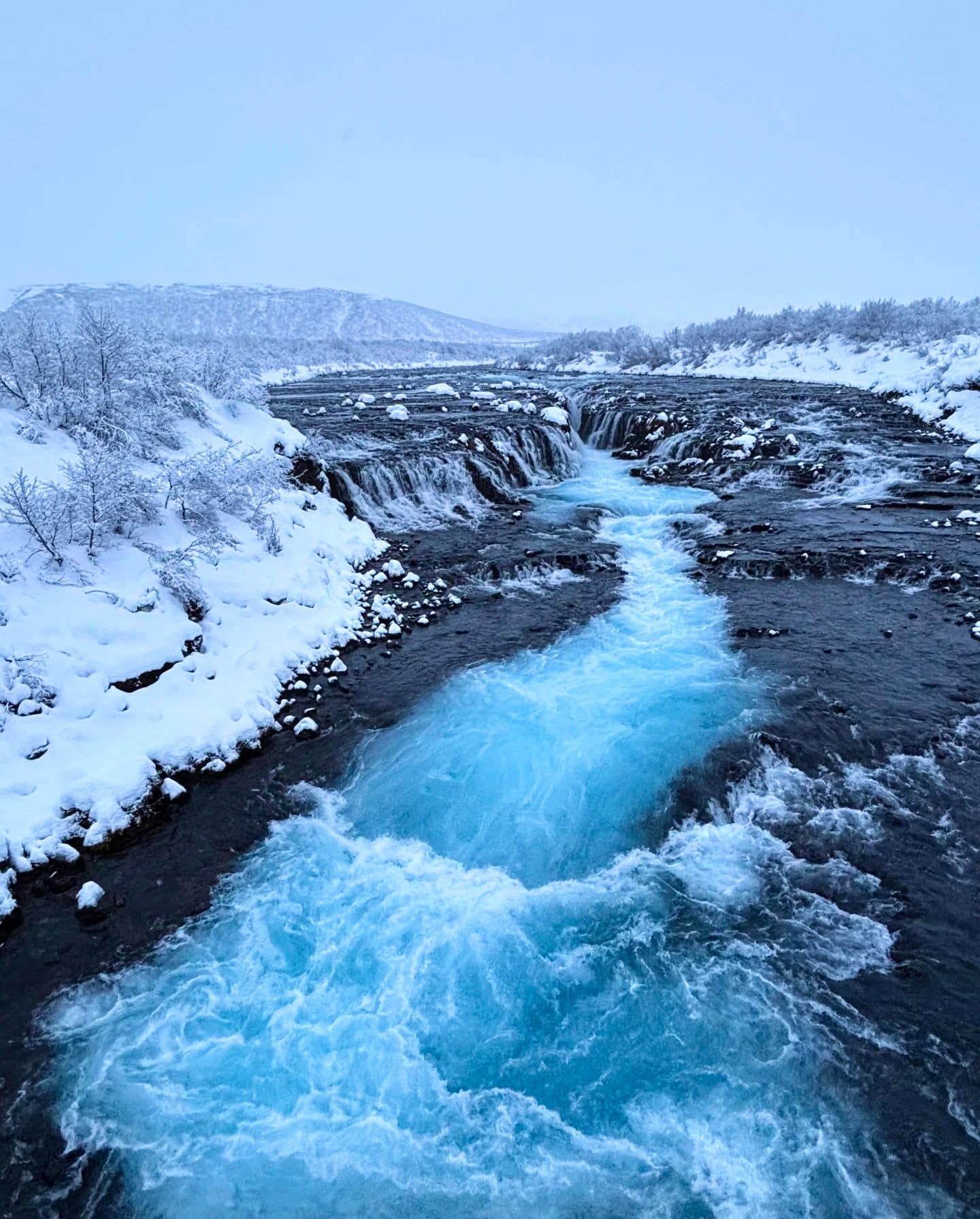 雪天路过Hvítá河，冰蓝水流像打翻了整片极光封面图