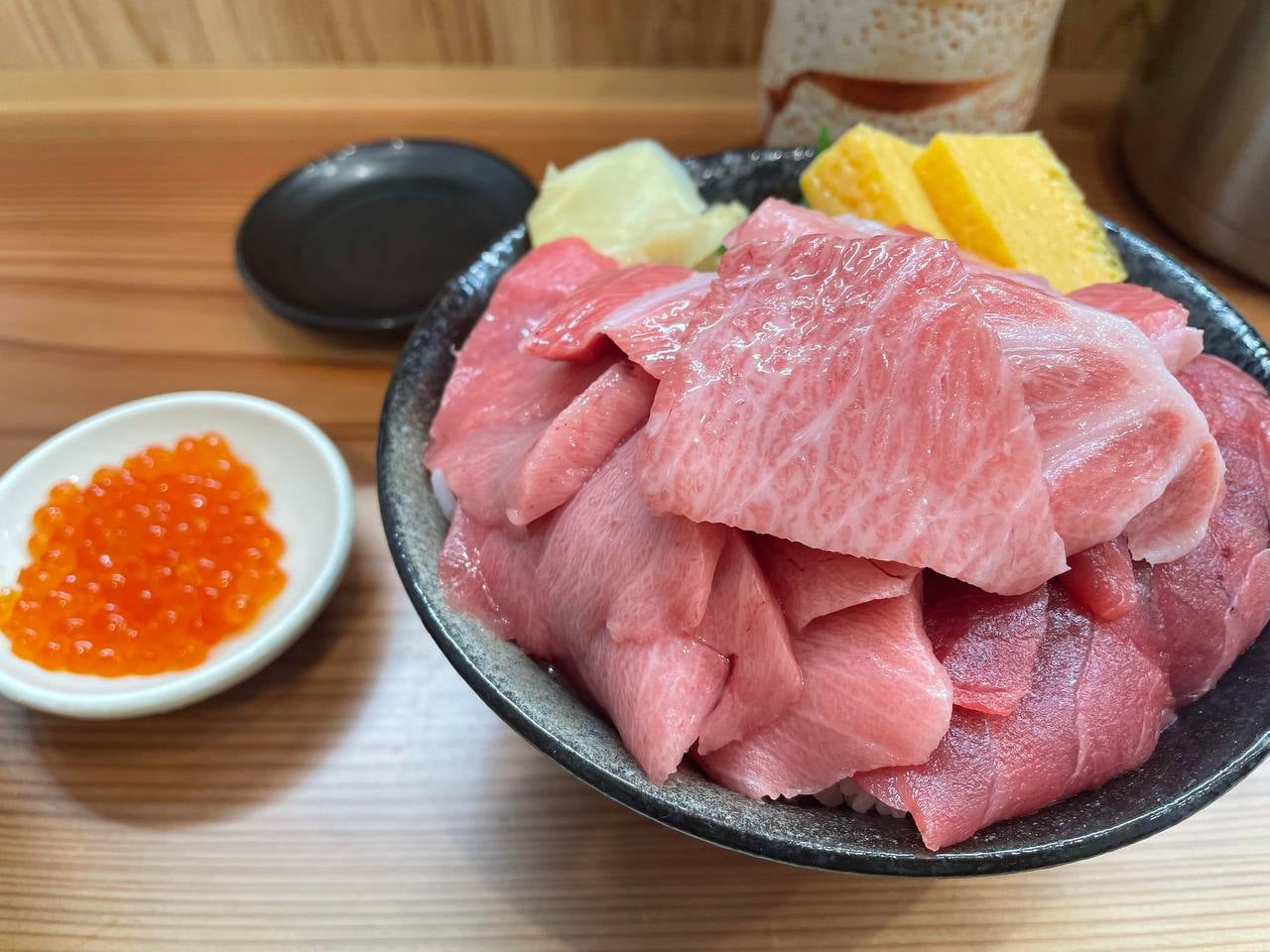 今天在街角小馆子啃了块肥瘦相间的金枪鱼腩，配着鱼子酱和玉子烧，一口入魂