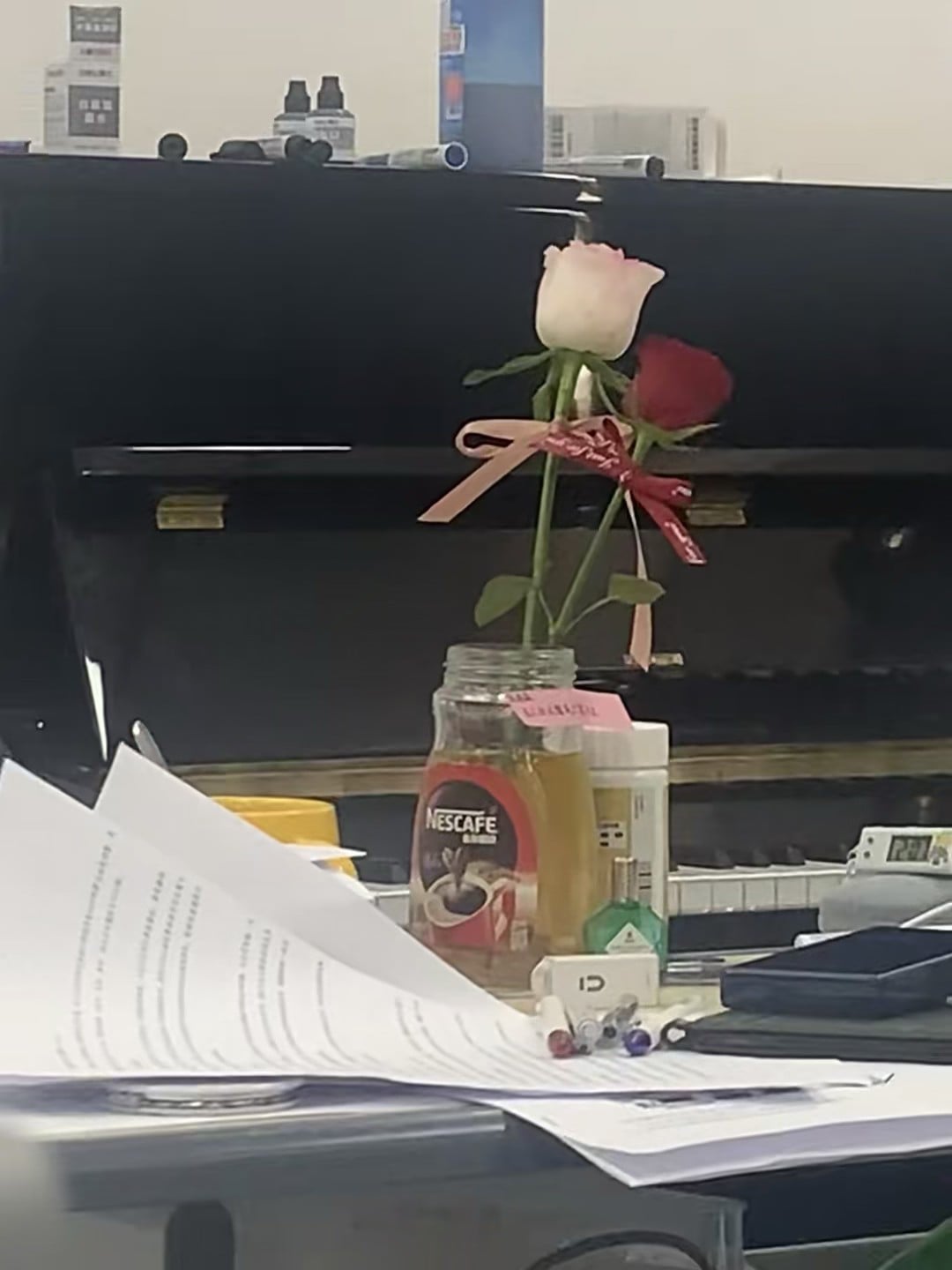办公室角落的浪漫：两支玫瑰插在Nescafé瓶里，今天是被温柔对待的一天
