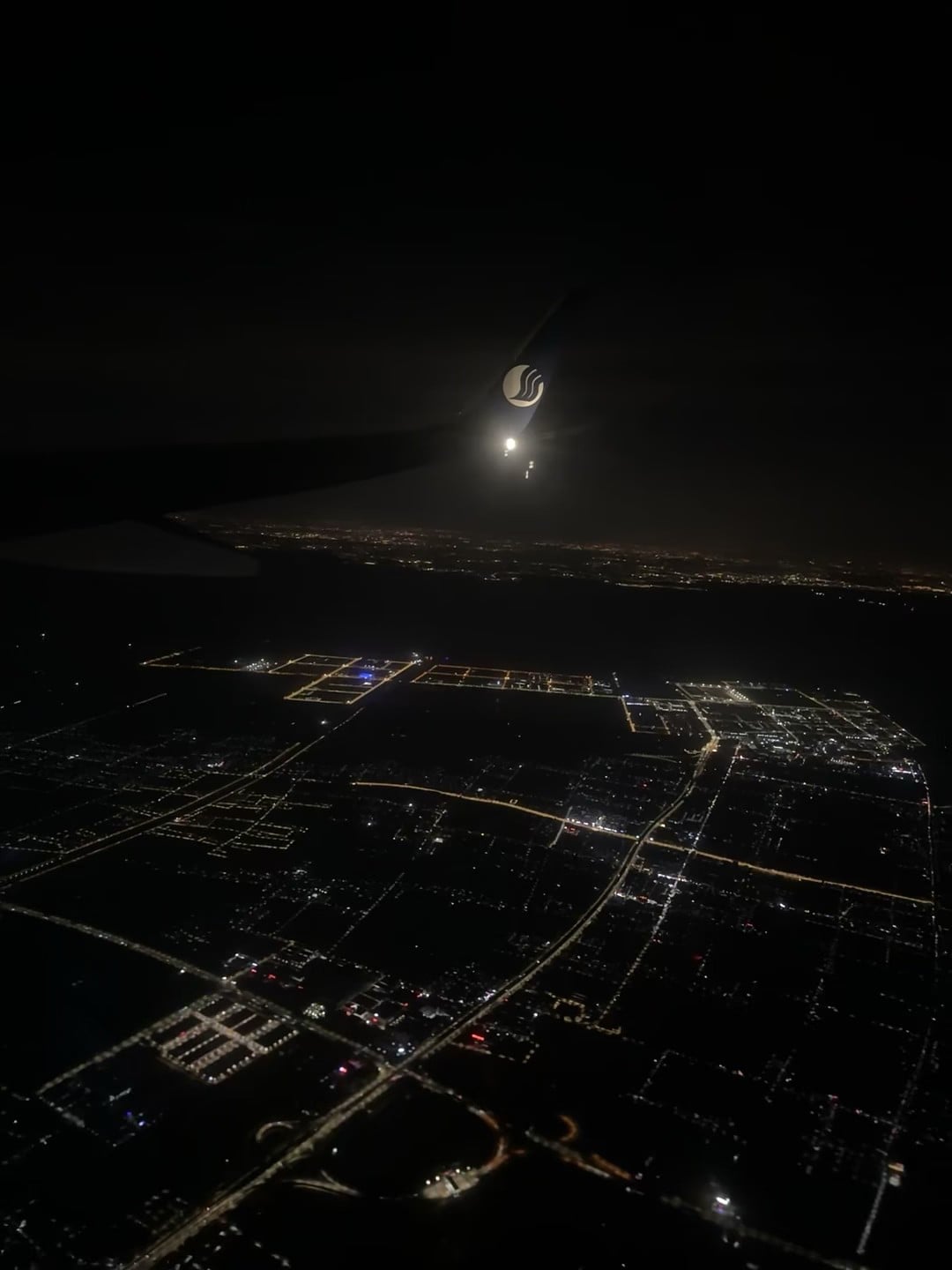 飞机舷窗拍的夜景，机翼上那个小标志在发光…今晚降落前的温柔时刻