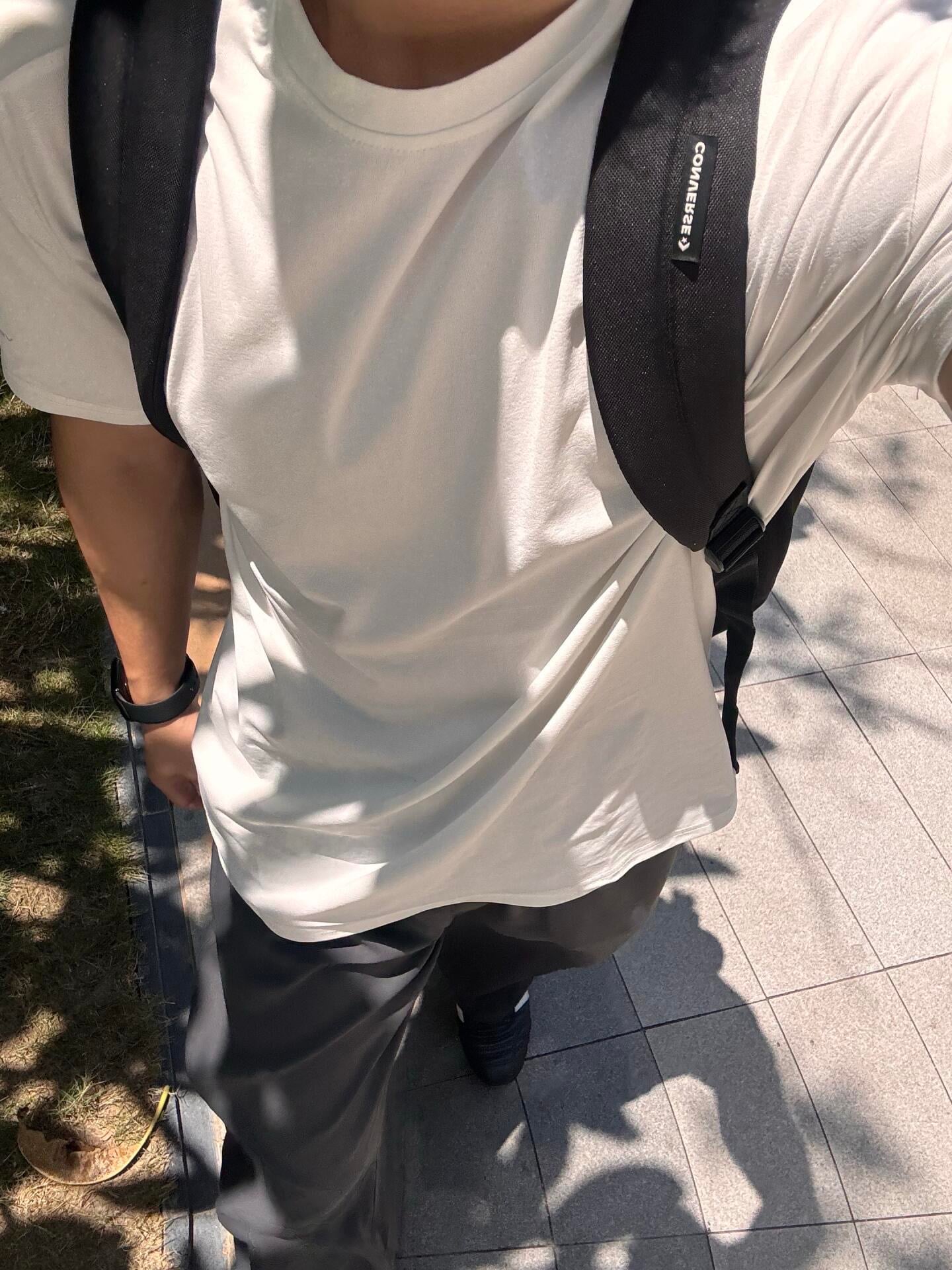今天穿了件白T配黑包，像极了刚从便利店出来被拍到的路人