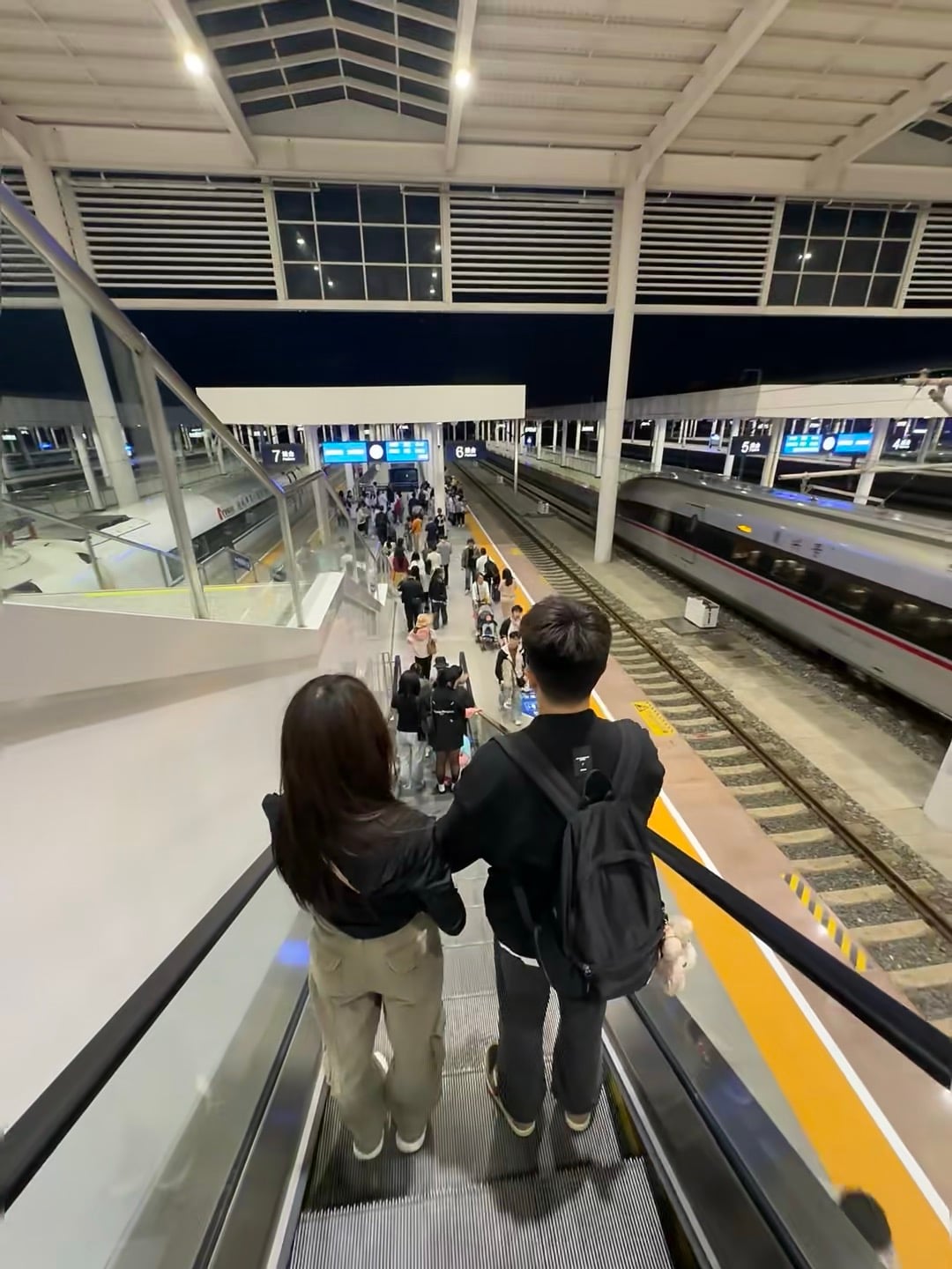 地铁口扶梯上偶遇的背影，像极了刚来异国时的我们