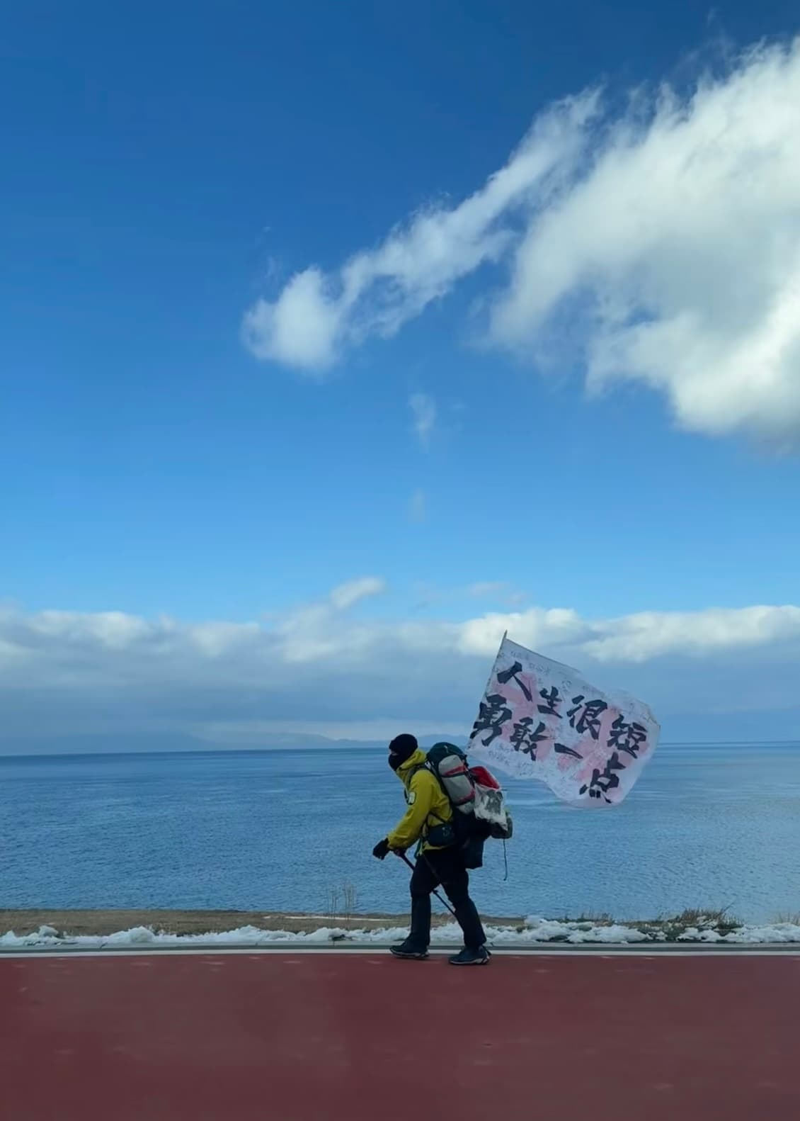 在青海湖边偶遇一位背包客,旗子上写着‘人生很短,勇敢一点’——瞬间被戳中了封面图