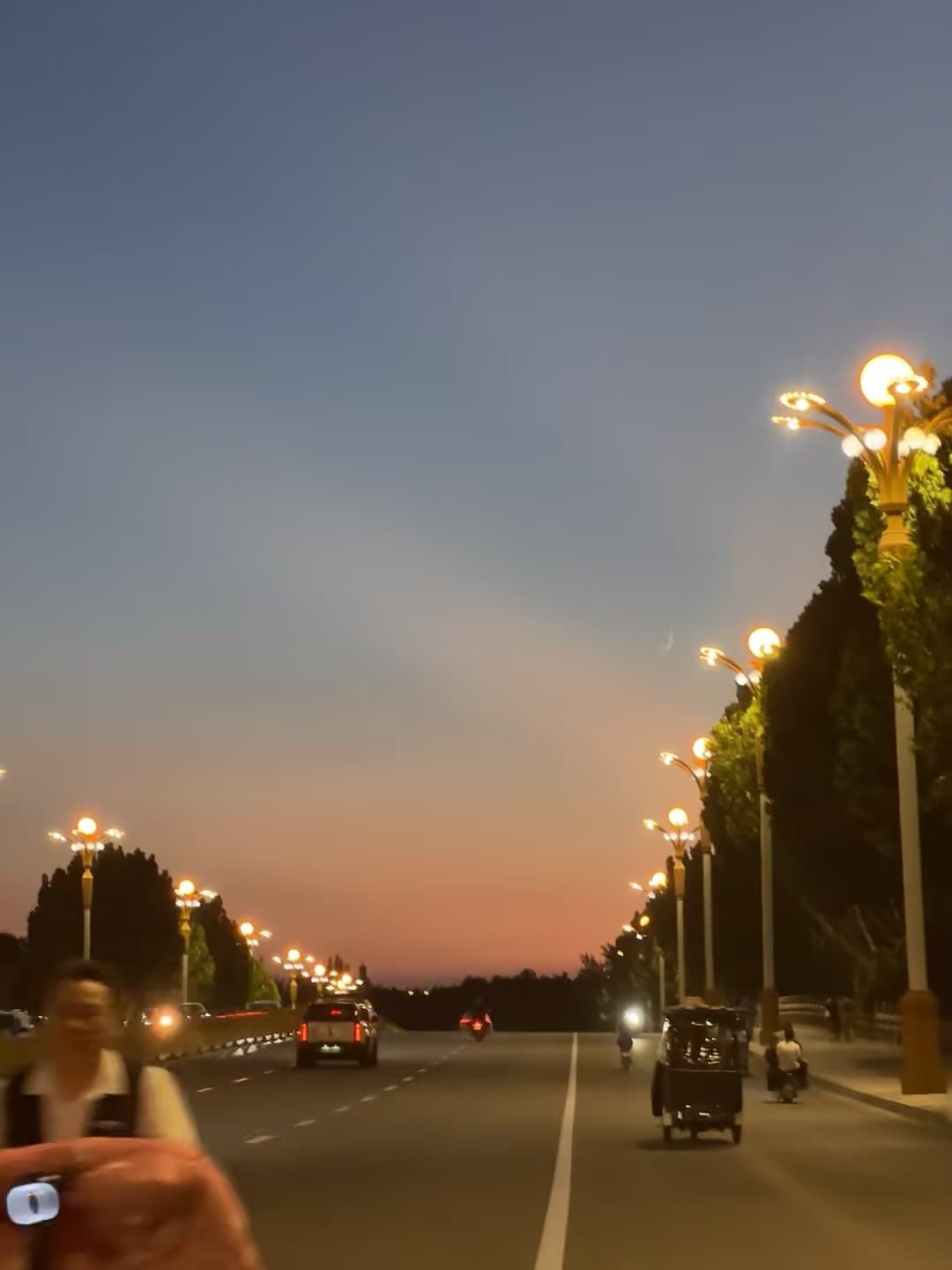 黄昏路灯亮起时,车流像被撒了金粉的河封面图